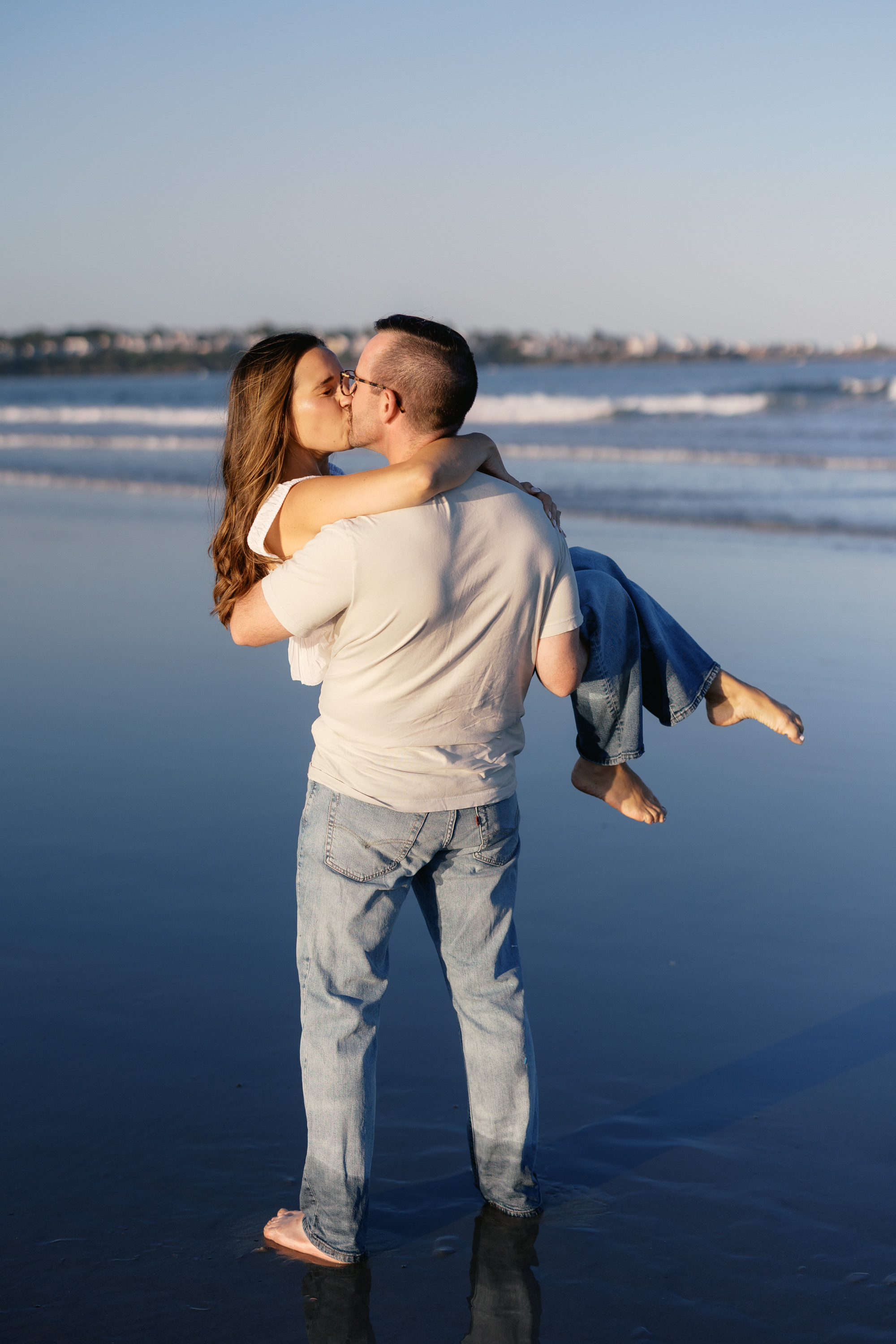Morgan carrying Julianne on the beach at sunset