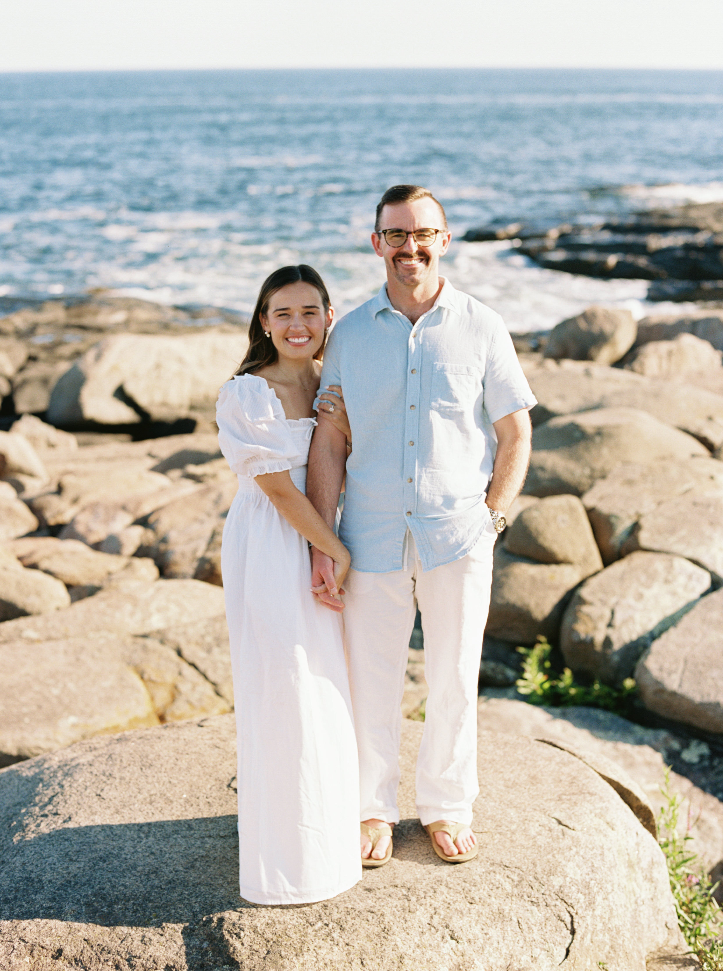 Julianne and Morgan posed on the rocks by the water